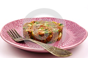 Beef Tartare cold appetizer of raw minced meat with egg yolk, spices, onions, olive oil, lemon juice