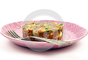 Beef Tartare cold appetizer of raw minced meat with egg yolk, spices, onions, olive oil, lemon juice