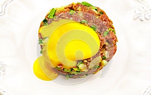 Beef Tartare cold appetizer of raw minced meat with egg yolk, spices, onions, olive oil, lemon juice