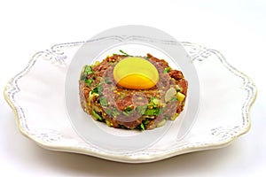 Beef Tartare cold appetizer of raw minced meat with egg yolk, spices, onions, olive oil, lemon juice