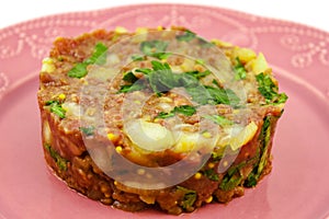 Beef Tartare cold appetizer of raw minced meat with egg yolk, spices, onions, olive oil, lemon juice