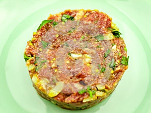 Beef Tartare cold appetizer of raw minced meat with egg yolk, spices, onions, olive oil, lemon juice