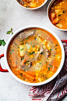 Beef and vegetables soup or slow stew in red saucepan. Winter comfort food concept