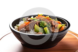 Beef and vegetables stir fry with jasmine rice in black bowl,