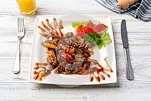 Beef and vegetables stir fry in a white plate on wooden table