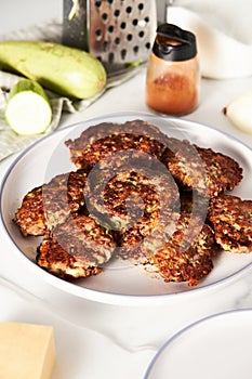 Beef, zucchini and cheddar cheese patties or cutlets on white plate. Dinner meat concept, full of proteins.