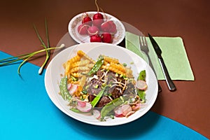 Beefsteak, french fries, pea legume, raw radish, sprout.