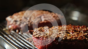 Beefsteaks frying on grill