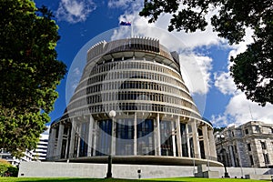 The Beehive, New Zealand`s parliament building with the New Zealand flag flying against a blue sky