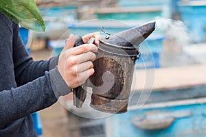 Beekeeper holds a chimney in his hand for fumigation of bees