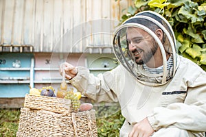 Beekeeper with honey on the apiary