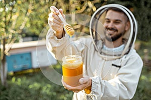 Beekeeper with honey on the apiary