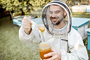 Beekeeper with honey on the apiary