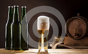 Beer barrel with three bottles and mug on brown background