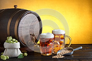 Beer barrel with two beer glasses and bag full of fresh hops