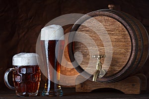 Beer barrel with two beer glasses on wooden table