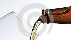 Beer being poured into glass against white background