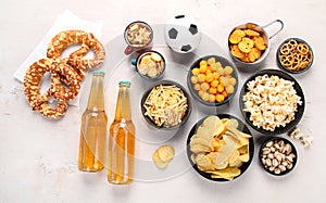 Beer bootles, snacks and ball on table