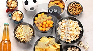Beer bootles, snacks and ball on table