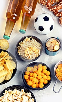 Beer bootles, snacks and ball on table