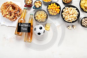 Beer bootles, snacks and ball on table