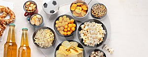 Beer bootles, snacks and ball on table