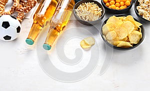 Beer bootles, snacks and ball on table