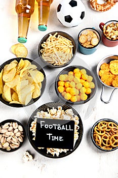 Beer bootles, snacks and ball on table
