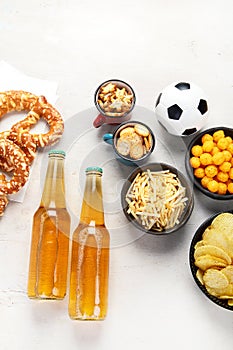 Beer bootles, snacks and ball on table