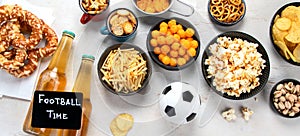 Beer bootles, snacks and ball on table
