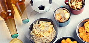 Beer bootles, snacks and ball on table