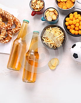 Beer bootles, snacks and ball on table