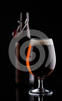 Beer bottle and a cup on a black background