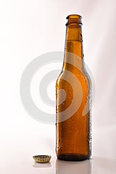 Beer bottle filled and open on glass table black background