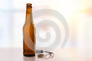 Beer bottle filled and open on glass table light background