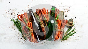 Beer in bottle and smoked sausage on white wooden background. Beer, Kabanosy. Top view.