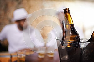 Beer bottles, alcohol and beverages with men by bar, pub or nightclub for drinking, socializing or partying. Ciders, ice