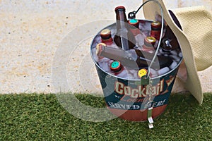 Beer bottles in a bucket with ice by the pool