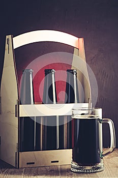 beer bottles case and mug on a red light background/beer bottles case and mug on a red light background. Selective focus