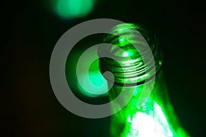 Beer bottles of green glass in a bar on dark background