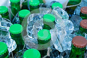 Beer Bottles in Ice Cubes, Many Cold Bottle Caps in Box, Iced Chilled Beer Chest, Different Cold Bottles