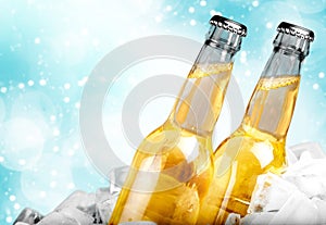 Beer bottles in ice on light background