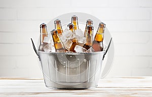 Beer bottles in metal basket with ice cubes on light background for party drink