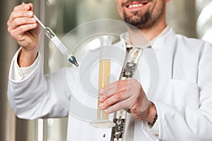 Beer brewer in his brewery examining