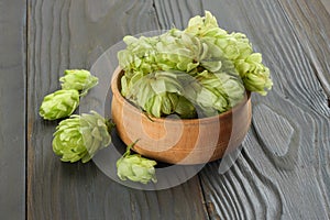 Beer brewing ingredients Hop cones in wooden bowl and wheat ears on dark wooden background. Beer brewery concept. Beer background