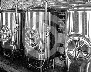 Beer brewing kettles. Stainless steel. Brick background.