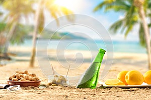 Beer buried in sand with aperitif on a beach