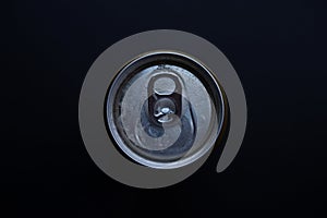 Beer can from above on a dark background.