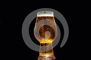 Beer. Cold Craft light Beer in a glass with water drops on the black background