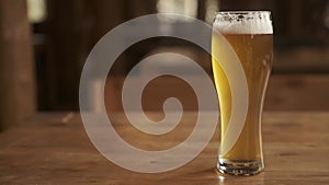 Beer. Cold Craft light Beer in a glass with water drops. Pint of Beer close up on a wooden background.